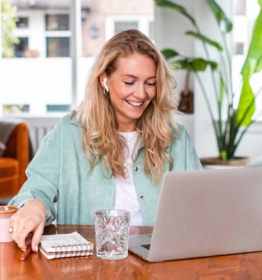 Een webshopondernemer bereid marketingcampagne voor achter haar laptop