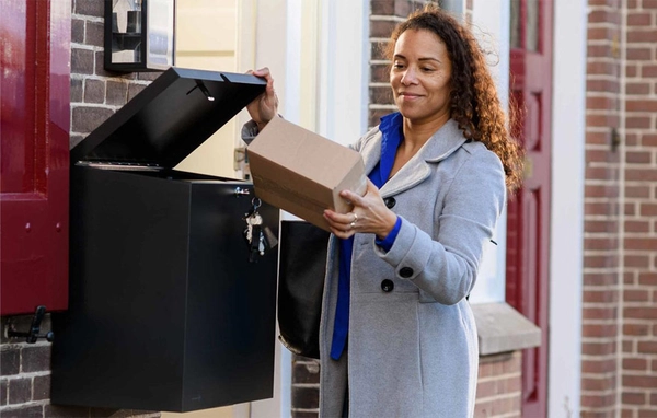 Vrouw doet een klein pakket in een pakketkluis