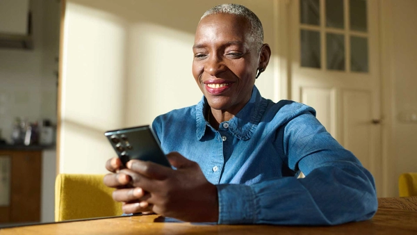Lachende vrouw checkt haar telefoon