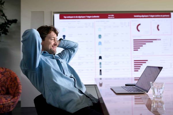 Webshop ondernemer kijkt in een tevreden houding naar zijn computerscherm omdat zijn Fulfilment goed geregeld is bij PostNL
