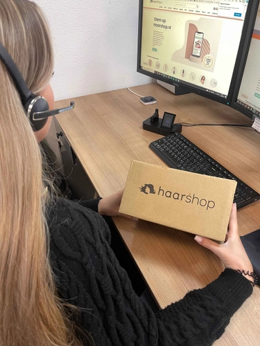 Klantenservice medewerker verwerkt een retourpakket achter de computer