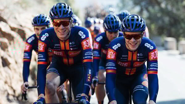 Een groep wielrenners van Team Picnic PostNL fietst samen over een bergachtige weg