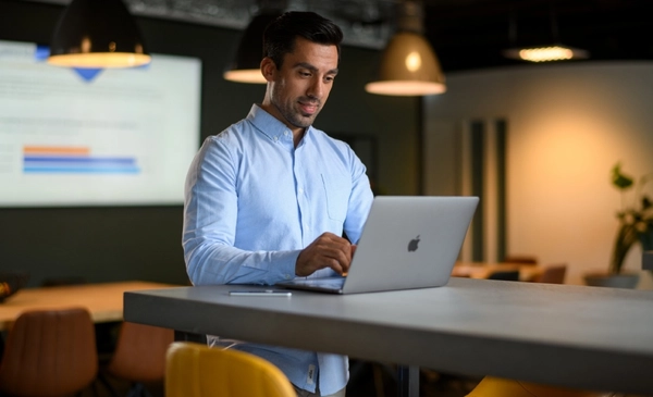 Professional werkt rustig op een laptop in een modern kantoor