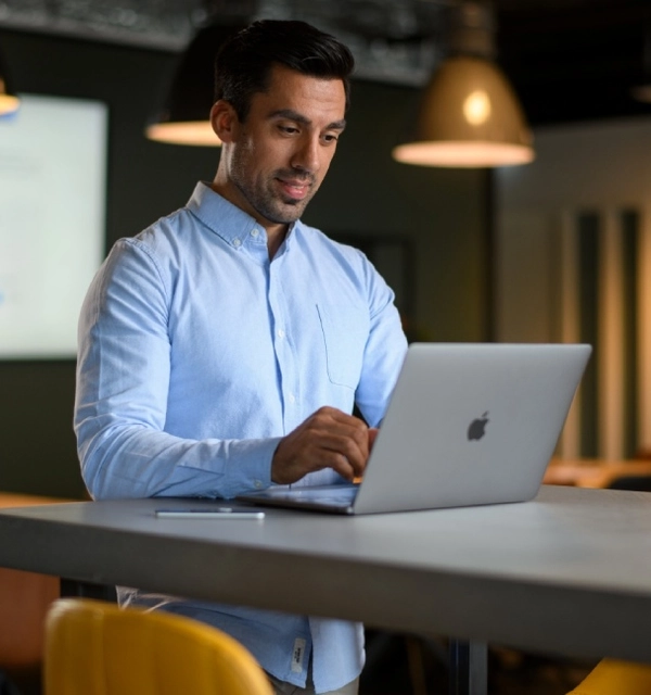 Professional werkt rustig op een laptop in een modern kantoor