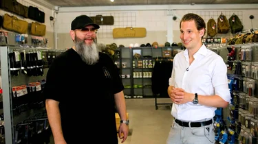 Twee mannen staan in een winkel met airsoft- en outdoorartikelen naast elkaar in gesprek