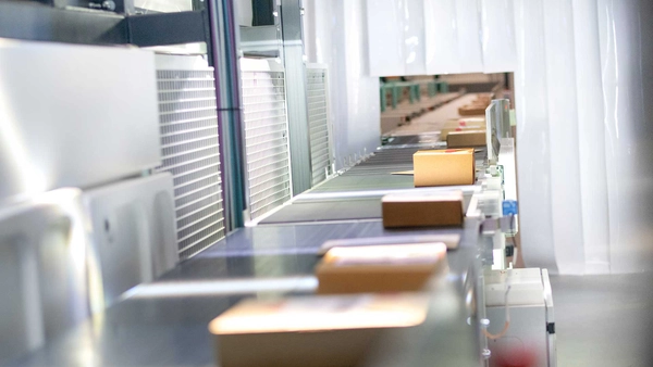 Pakketten rollen over een band in een sorteercentrum