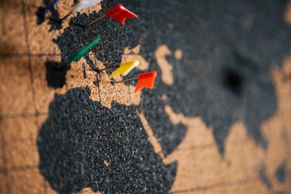 Wereldkaart als prikbord met vlaggetjes erin geprikt