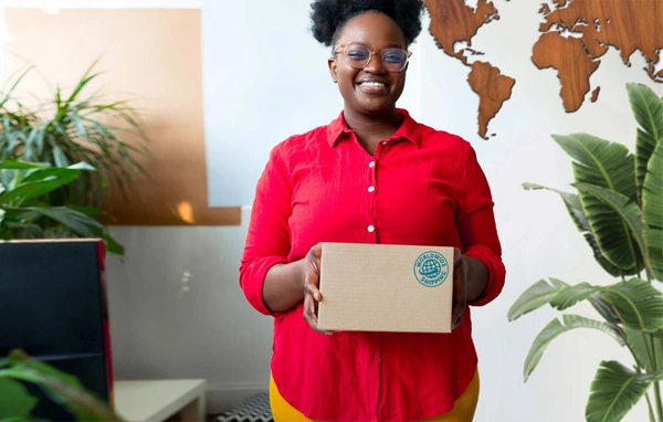 Vrouw houdt een pakket vast met een stempel waarop 'worldwide shipping' staat