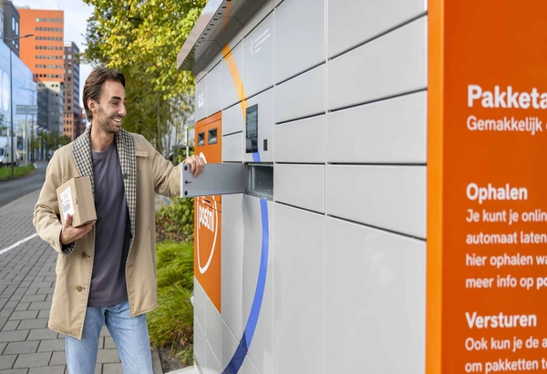Man haalt een pakket uit een PostNL-pakketautomaat