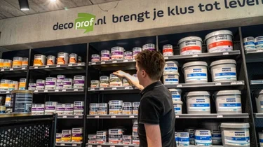 Pand van Decoprof met bedrijfslogo en vlag bij de ingang.