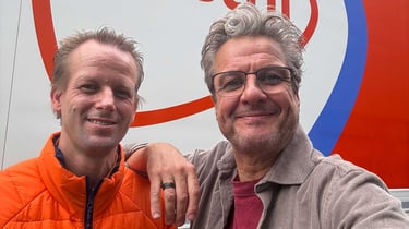 Maurice en PostNL-chauffeur poseren voor een PostNL-vrachtwagen.