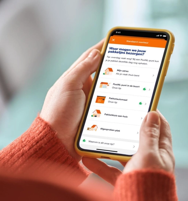 Consument houdt een telefoon vast met daarop een keuzescherm met bezorgvoorkeuren