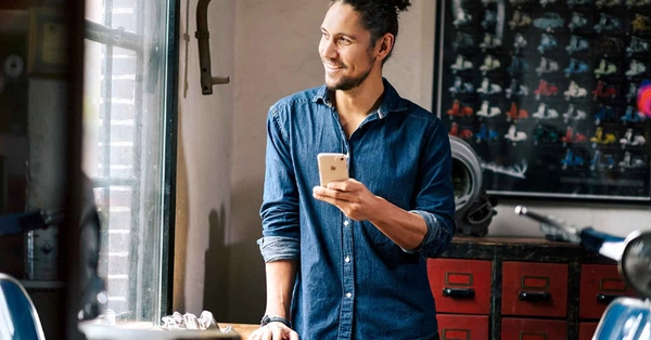 Lachende man met telefoon in zijn hand